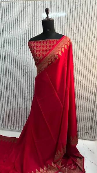 Red Banarasi silk saree with gold zari border draped on a mannequin